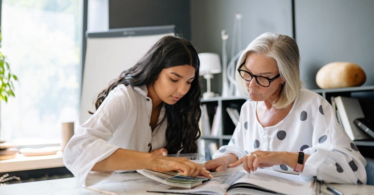 Two women engaged in a collaborative meeting at an office, emphasizing diversity and teamwork.