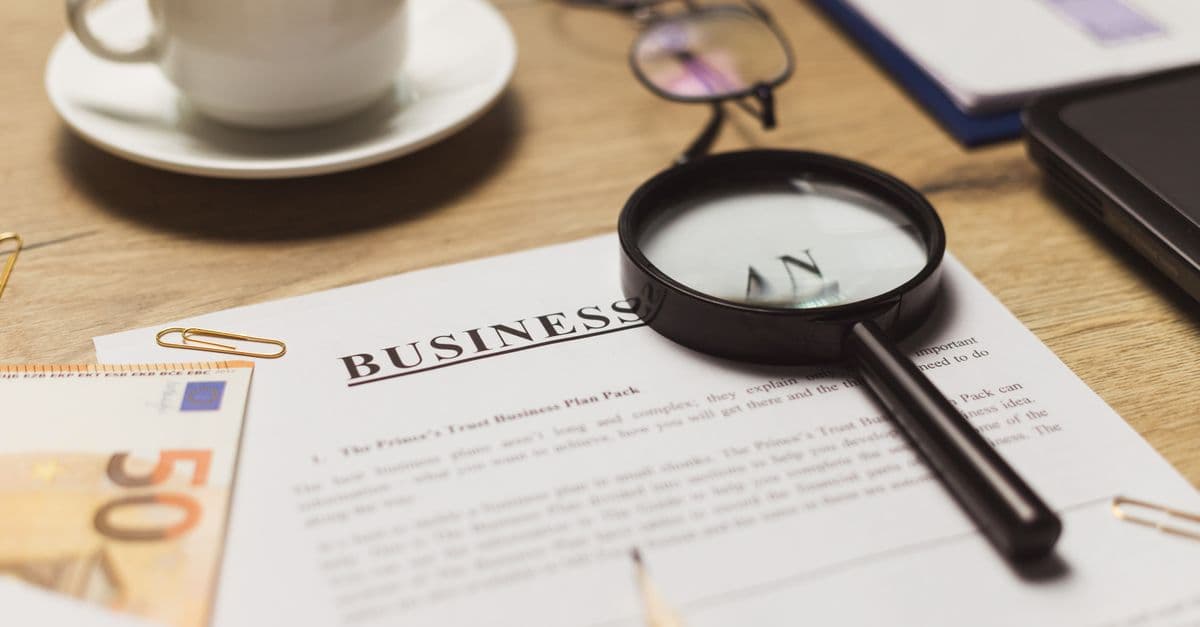 A business workspace setup featuring documents, coffee, and financial elements.